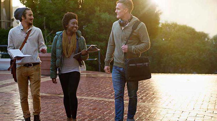 Three college students walking on campus.